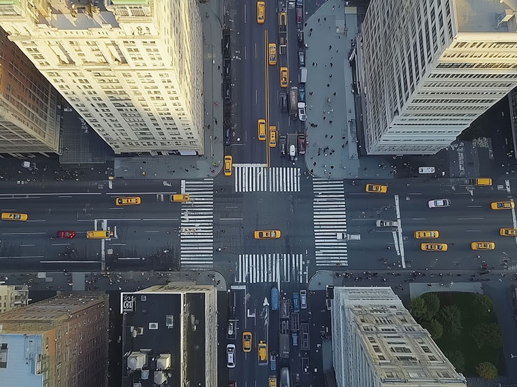 Bird’s-eye view of a busy New York City intersection with yellow taxis and pedestrians, illustrating dangerous intersections in NYC
