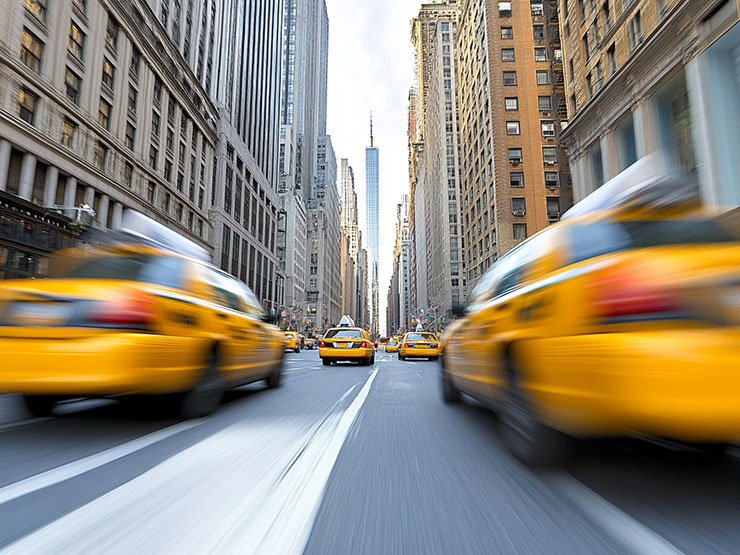 Multiple yellow cabs driving on a busy city street, illustrating Manhattan taxi traffic and accident risk
