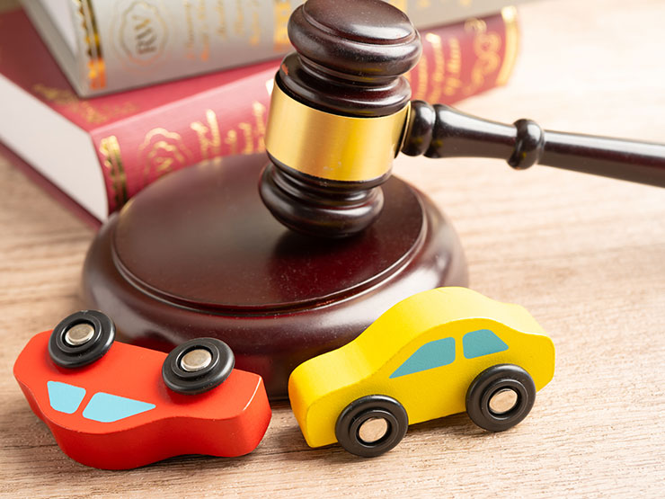 Gavel beside a car model, representing a legal claim after a yellow cab accident in Manhattan