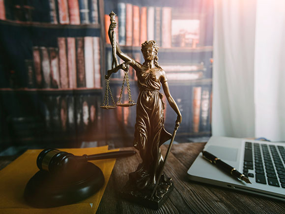 Lawyers reviewing contract papers beside brass scales of justice on an office desk, representing trial-ready guidance from a New York City bicycle accident lawyer