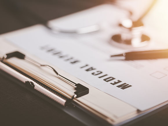 Stethoscope resting on a medical report on a desk, representing medical documentation used to prove injuries in a New York City rideshare accident claim