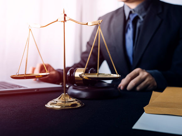 Lawyers reviewing contract documents beside brass scales of justice on an office desk, representing trial-ready guidance from a New York City slip and fall lawyer
