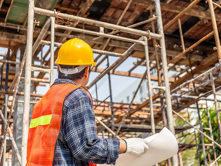 Construction worker in a hard hat reviewing plans, related to New York Labor Law 240 scaffold law claims