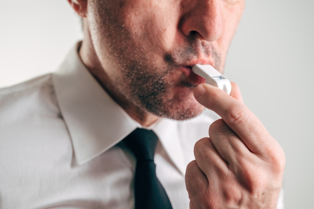 Businessman with whistle in mouth representing whistleblower concept, corporate ethics, transparency, responsibility, and exposing wrongdoing in business or finance. Selective focus.