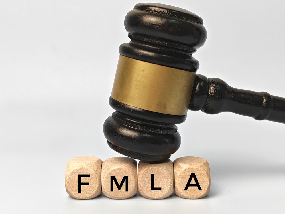 Family Medical Leave Act FMLA Legal Concept with Judge Gavel on Wooden Blocks Representing Employment Rights Workplace Compliance and Labor Law.