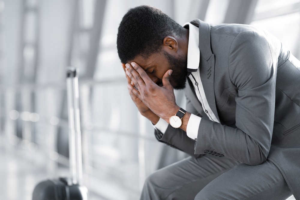 Distressed businessman sitting with head in hands after losing his job